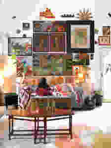 Colorful gallery wall in living room with pink, red and oranges.