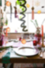 Cheerful holiday table setting with moss, dried citrus, snowflakes, tassels, vintage tableware