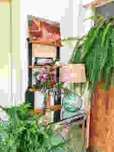 Front hall with fern, nordic pine and bouquet on mirrored table. Oil painting on shelf