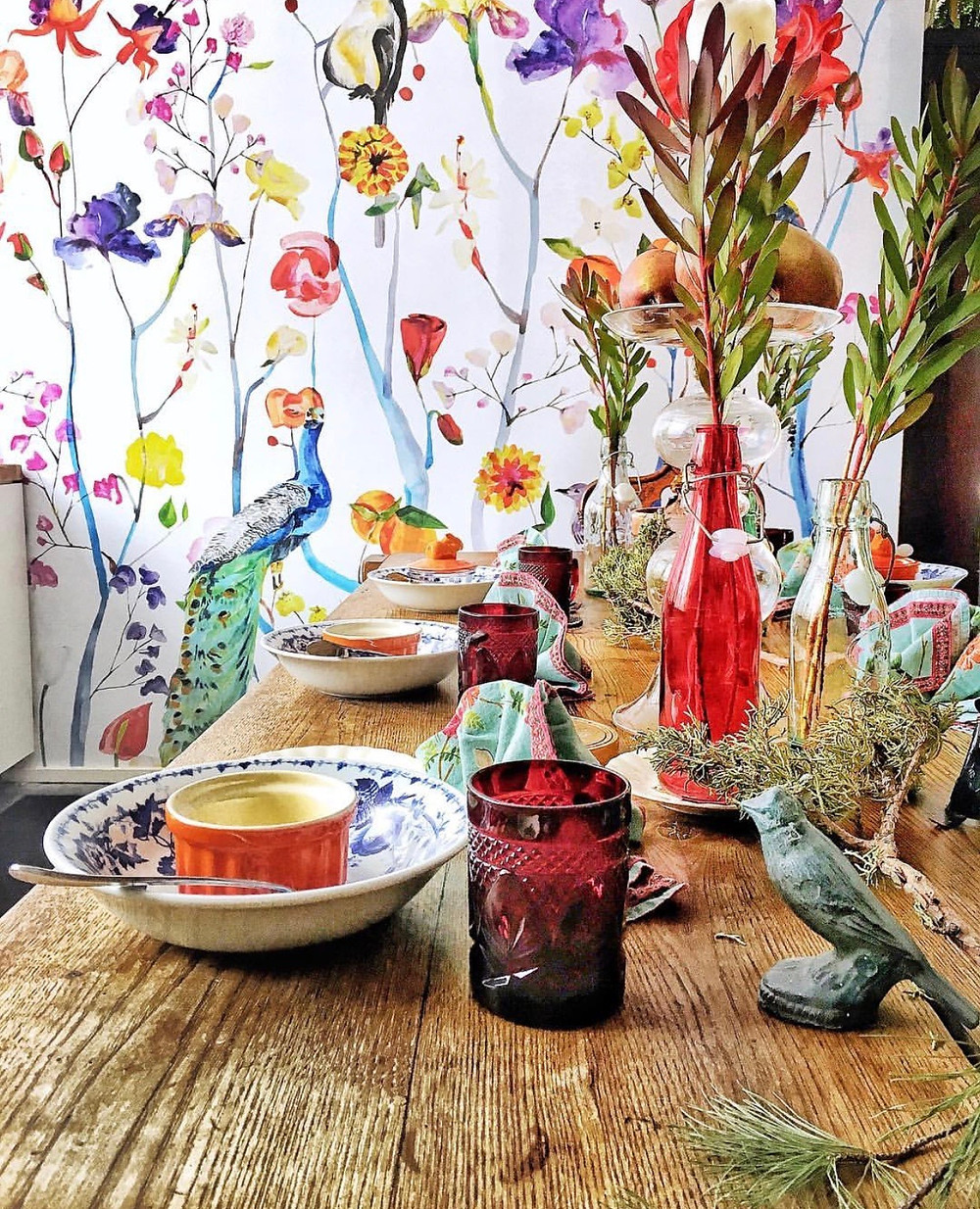 floral wallpaper, red vintage cups, table setting with a whimsical style
