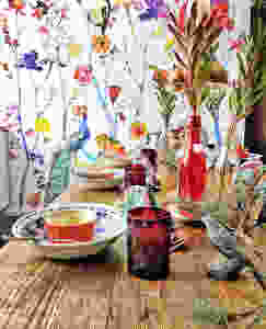 floral wallpaper, red vintage cups, table setting with a whimsical style