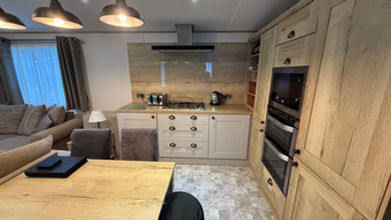 Modern kitchen interior with wooden cabinets and integrated appliances; bright and airy.