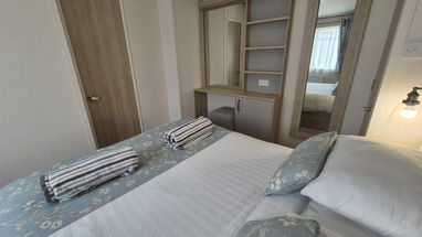 Bedroom interior with bed, pillows, wardrobe and mirror. SOUTHWEST CARAVAN CONSULTANTS.