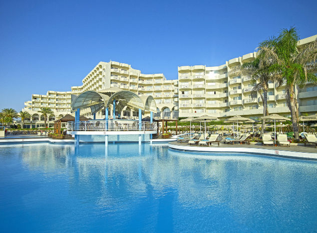A hotel pool with the main building in the background