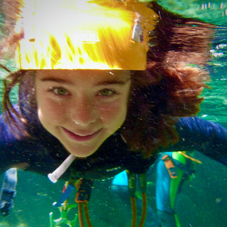 Partecipanti che riemergono sorridendo dall'acqua profonda durante un'escursione di canyoning con Alp Adventure, dimostrando l'ottimo galleggiamento della muta.