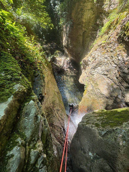 Participant abseiling down a waterfall in the Rio Selvano canyon, Tuscany, during a guided canyoning adventure in the beautiful setting of Fabbriche di Vallico.