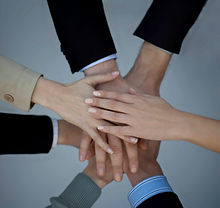 Team members putting their "hands in" for a group project