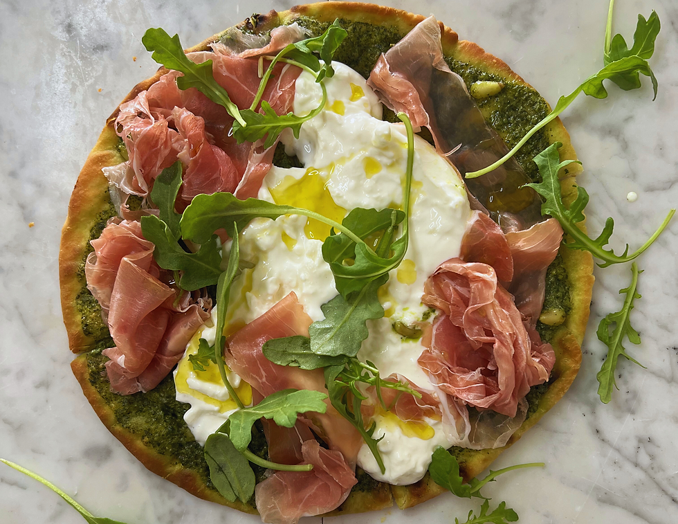 Burrata Pesto Pizza with Prosciutto & Arugula. Finished with a drizzle of extra virgin olive oil