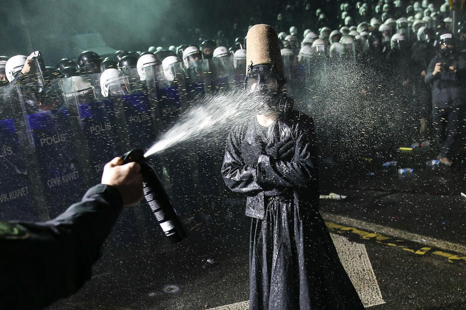 Masses of Police with a demonstrator how is sprayed with teargas