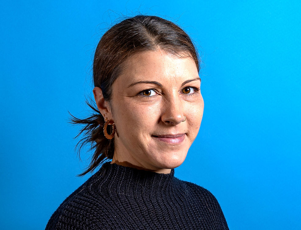 Portrait-Foto einer Frau mit zusammengebundenen schwarzen Haaren. 