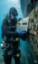 Diver replacing zinc anode on a ship hull underwater