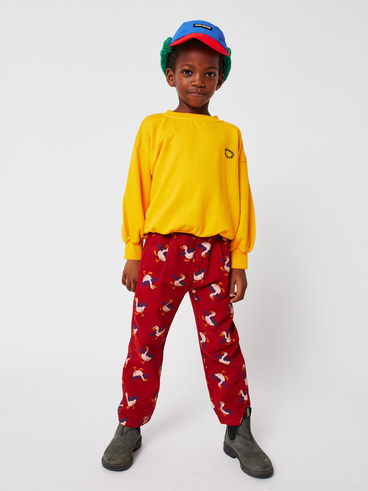 Model in yellow Mr Pencil Sweatshirt paired with red trousers by Bobo Choses
