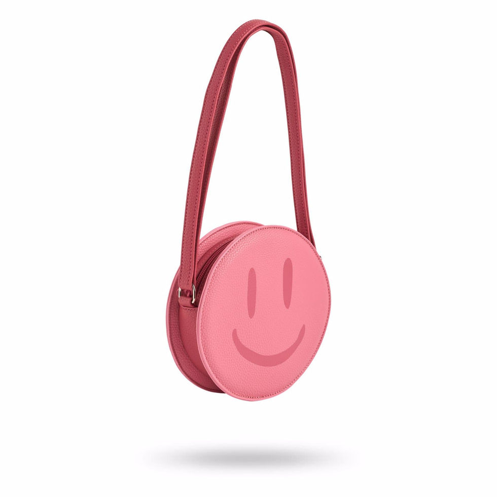 Pink round children’s crossbody bag with a smiley face design and shoulder strap.