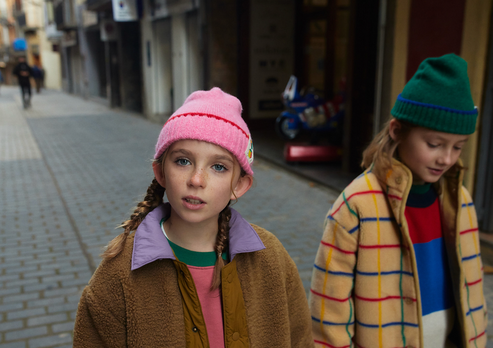 Girl wearing pink beanie outdoors paired with a brown coat