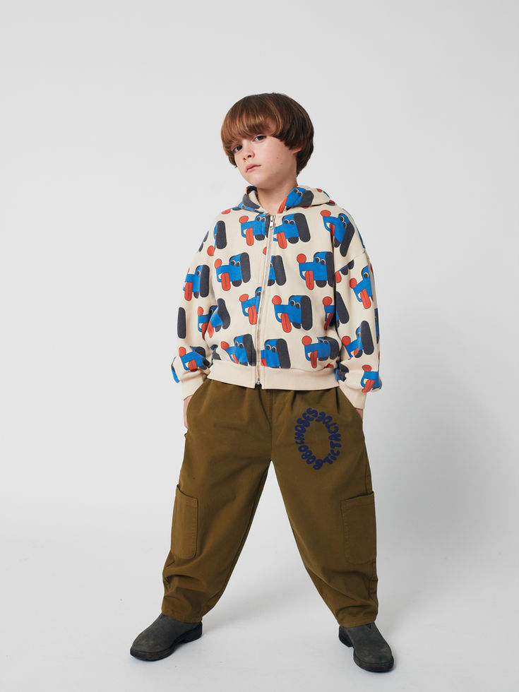 Child standing wearing khaki Tic Tac Toe Woven Cargo Pants and patterned hoodie