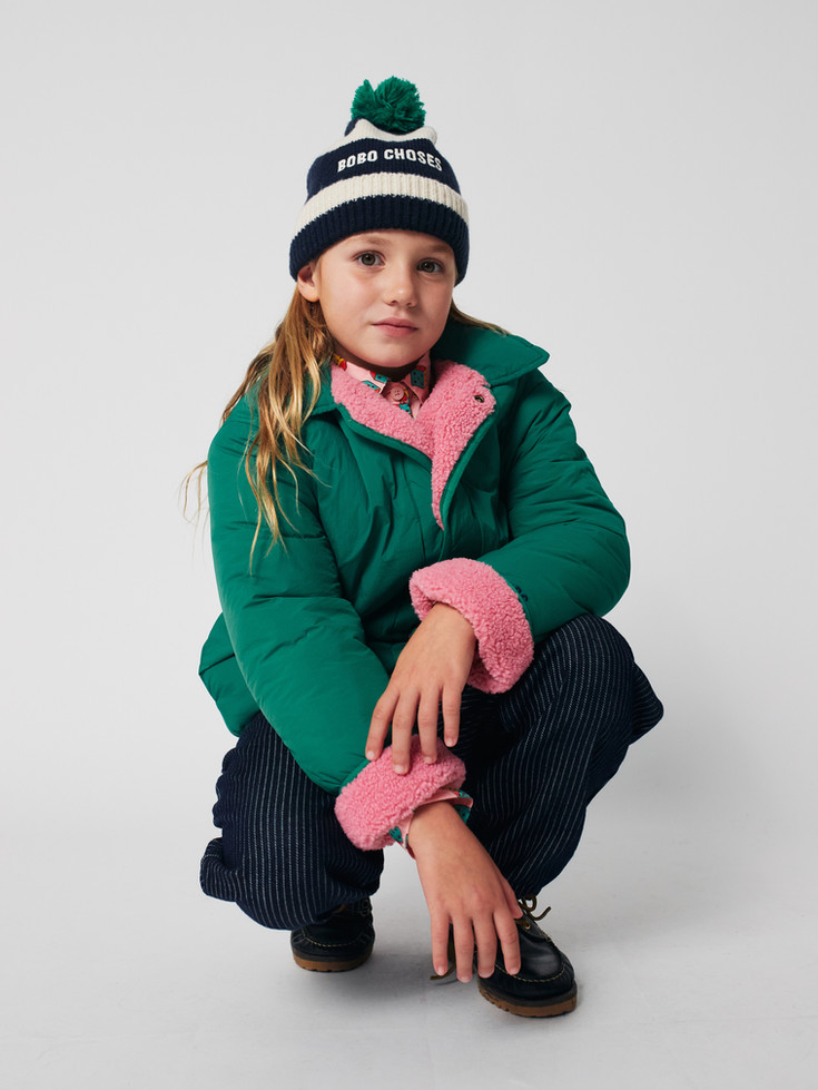 Model sitting down wearing green clover print jacket