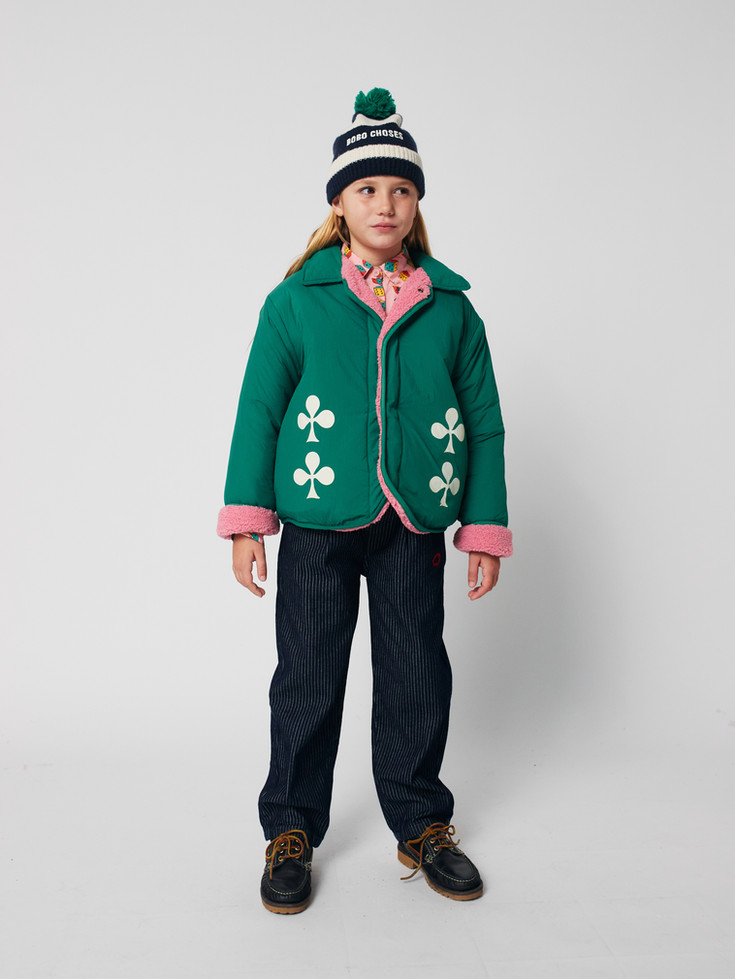 Child styling green clover jacket with dark pants