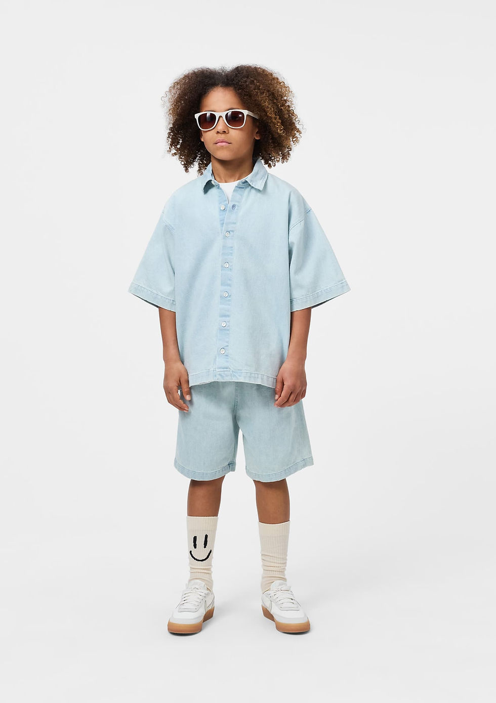 Child standing and facing forward, wearing the light blue shirt and matching shorts.