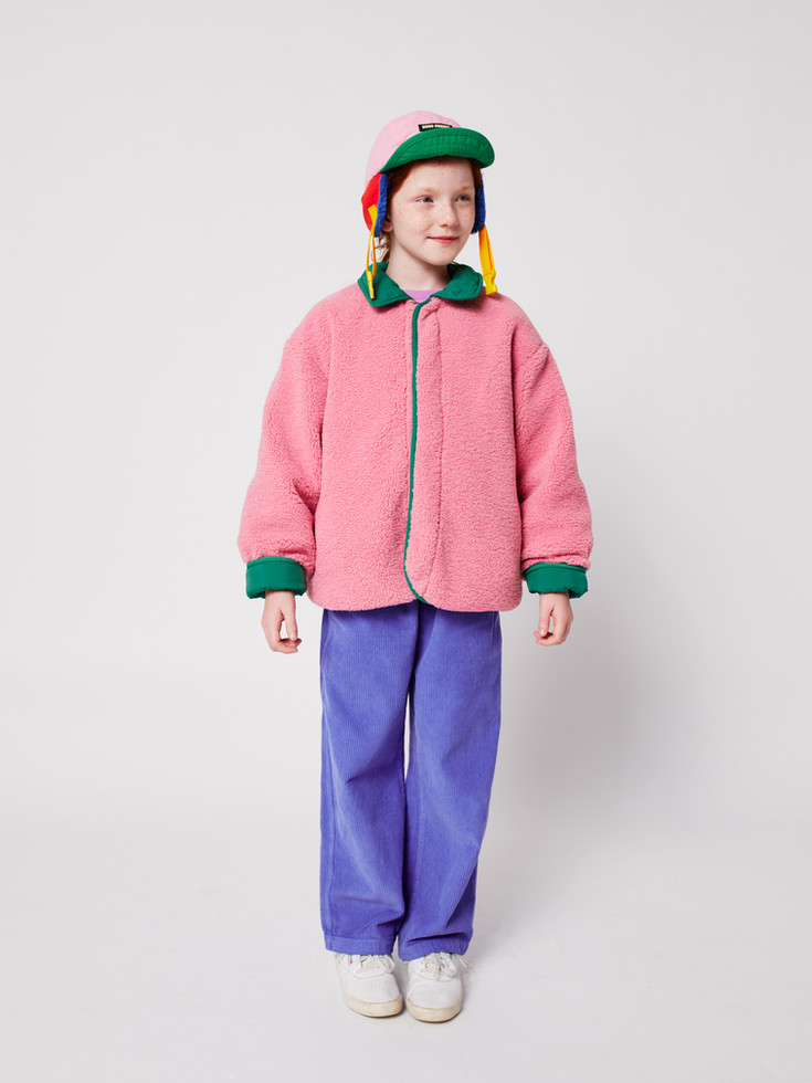Model showing pink sheepskin jacket with purple trousers