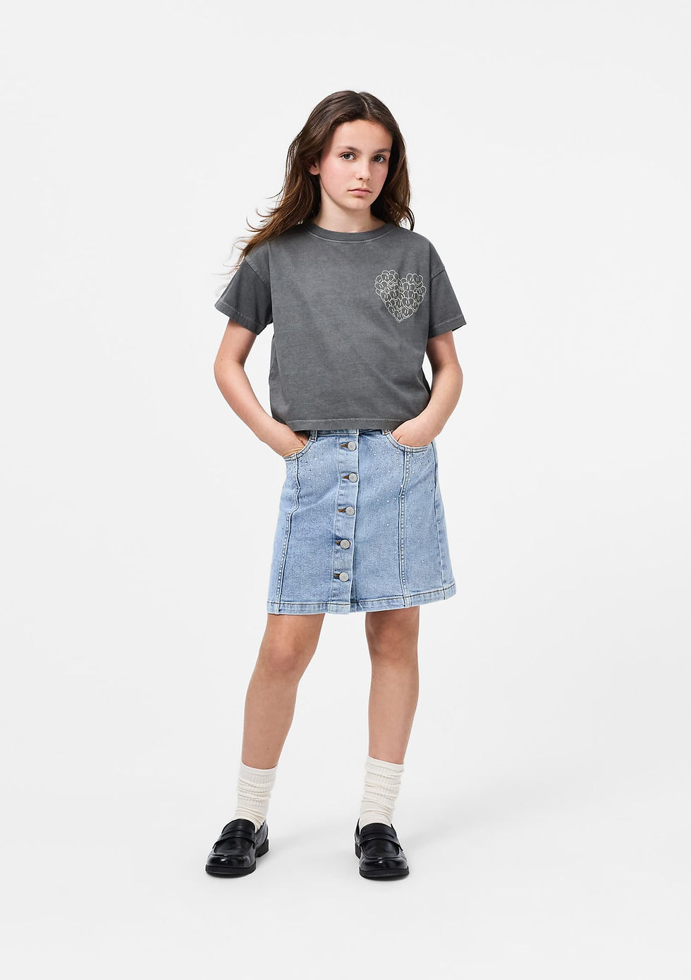 Child standing and facing forward, wearing the denim skirt with a grey T-shirt.