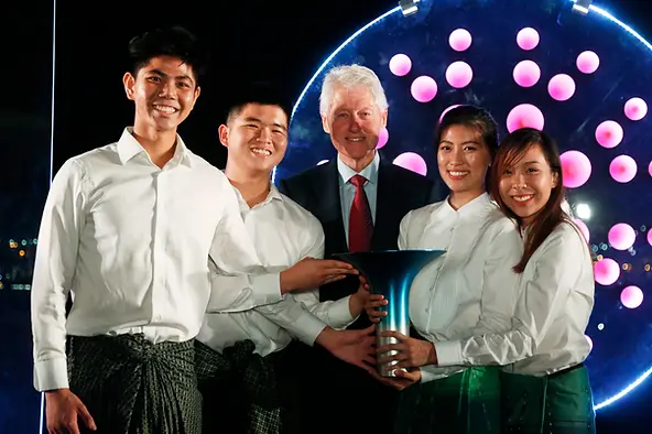 Bill Clinton com os premiados do Hult Prize em 2018: os jovens vestem sarongues tradicionais em homenagem aos plantadores de arroz que buscam aujdar (Foto: Divulgação)