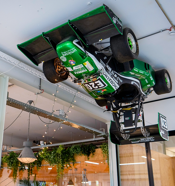 Een groene racewagen aan het plafond in het kantoor.