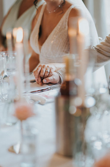 Bride and groom holding hands at the top table of their wedding breakfast in The Reception Room at Ashfield House. Taken by Bobtale Photography.