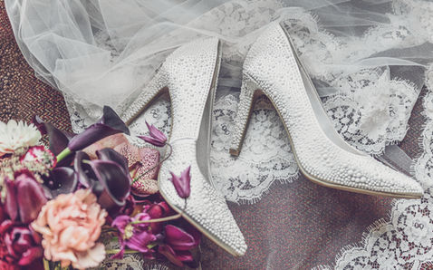 Escarpins de mariée blancs perlés sur dentelle avec fleurs.