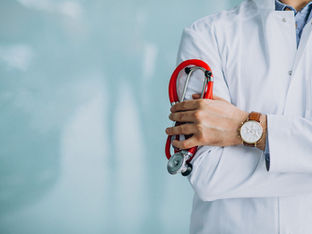Médico com jaleco branco e estetoscópio vermelho em mãos