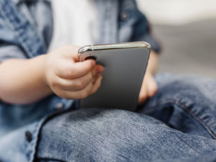 Criança segura smartphone na mão