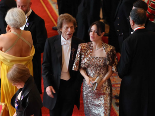 Mick Jagger, vocalista da banda The Rolling Stones, ao lado de sua parceira, Melanie Hamrick, em um evento formal.