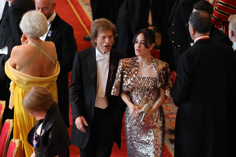 Mick Jagger, vocalista da banda The Rolling Stones, ao lado de sua parceira, Melanie Hamrick, em um evento formal.