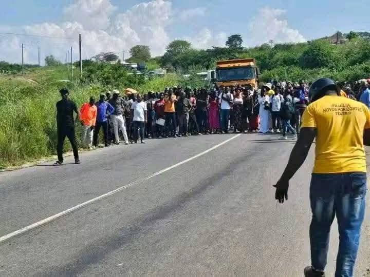 Diversas pessoas paradas no meio da estrada
