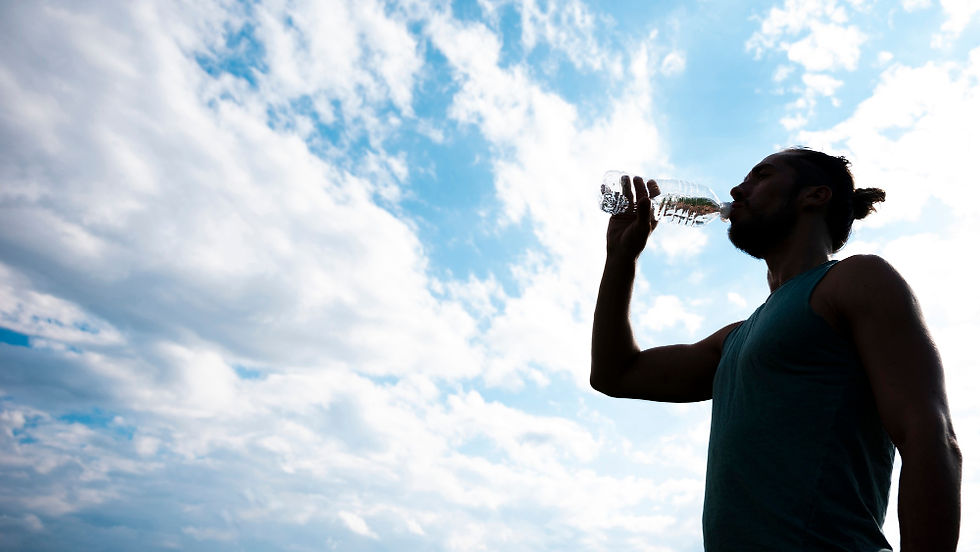 Homem contra o sol tomando água