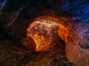 Fotografia de baixo ângulo de um buraco redondo como entrada de uma caverna