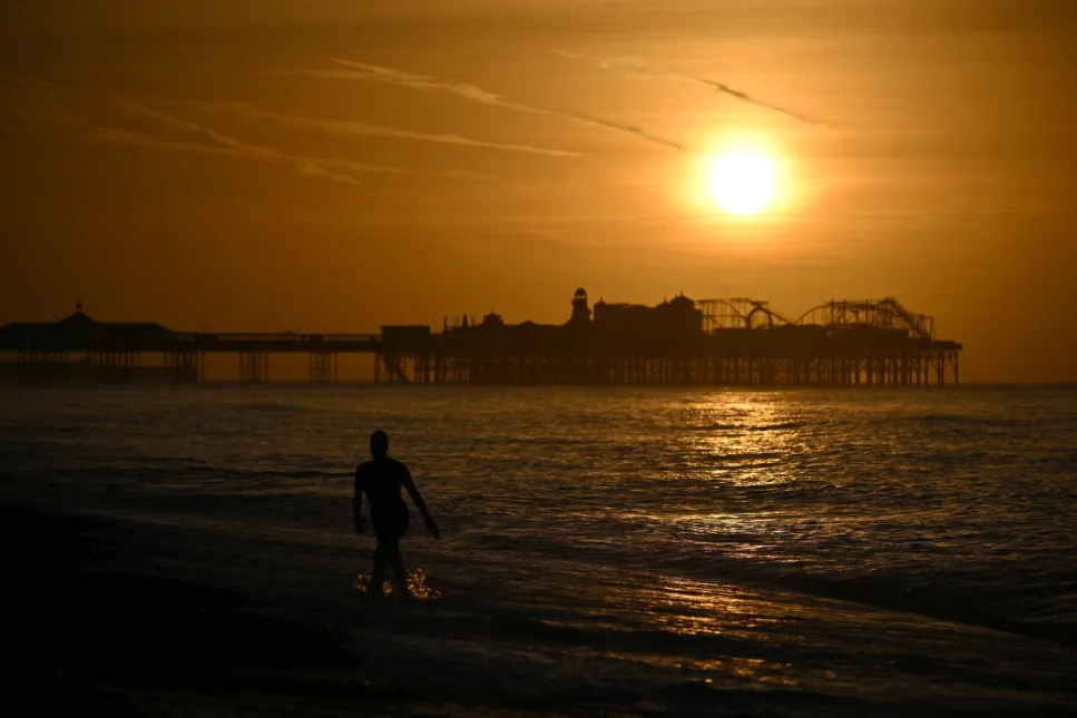 Imagem do sol ao fundo em uma paisagem de praia