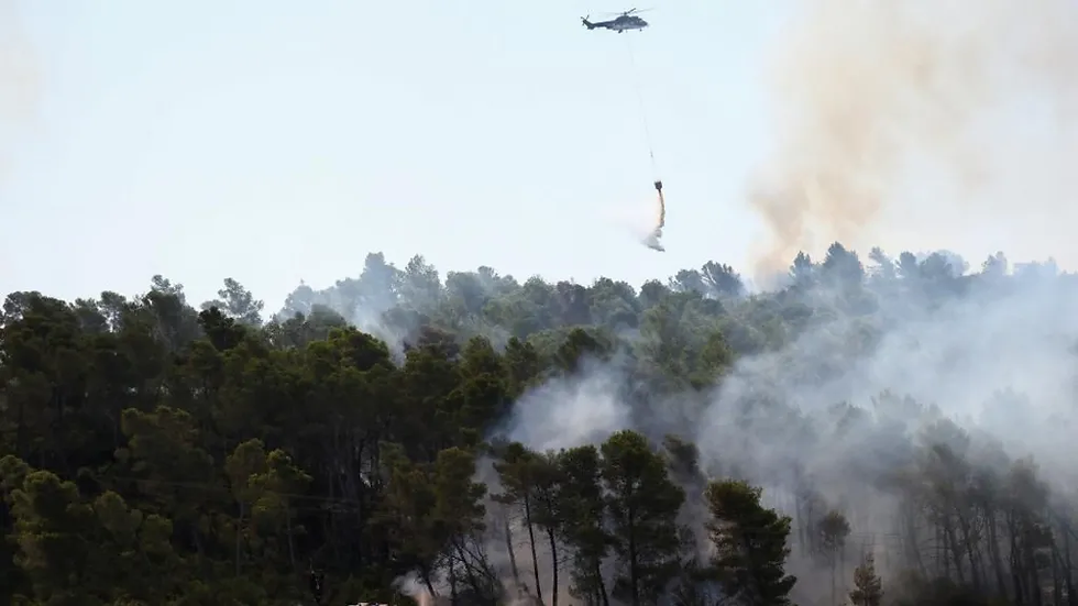 Helicóptero lança água em incêndio