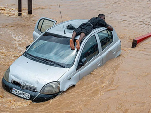 Imagem mostra carro no meio de inundação, homem busca refúgio acima do veículo
