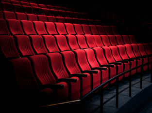 Interior de um cinema com poltronas vermelhas