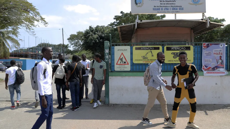 Estudantes caminham em frente a instituição de ensino