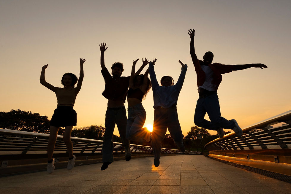 Amigos a saltar ao pôr-do-sol
