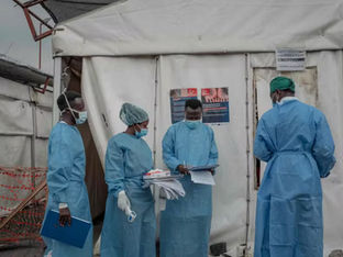 Médicos conversam em frente à tenda de tratamento
