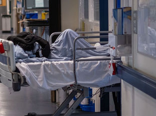Paciente em maca no corredor de hospital
