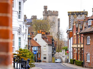 Rua de Arundel com casas antigas e castelo ao fundo