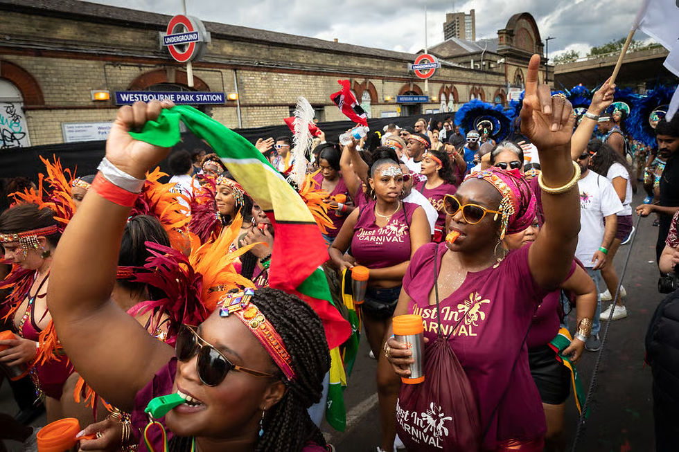 A imagem mostra pessoas festejando no Carnaval de Notting Hill