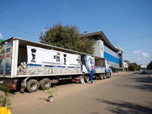 A imagem mostra caminhões com ajuda humanitária da "Zim Aid", provavelmente destinados a uma área necessitada no Zimbábue.
