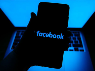 Pessoa segura Smartphone com logotipo do Facebook aparecendo na tela