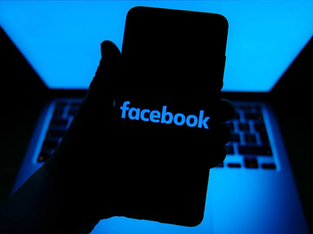Pessoa segura Smartphone com logotipo do Facebook aparecendo na tela