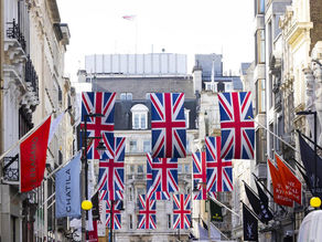 A imagem mostra a Bond Street em Londres, Inglaterra, decorada com bandeiras do Reino Unido, também conhecidas como Union Jack. 
