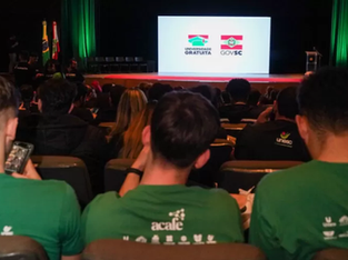 A imagem mostra um evento relacionado ao programa "Universidade Gratuita" do Governo de Santa Catarina.